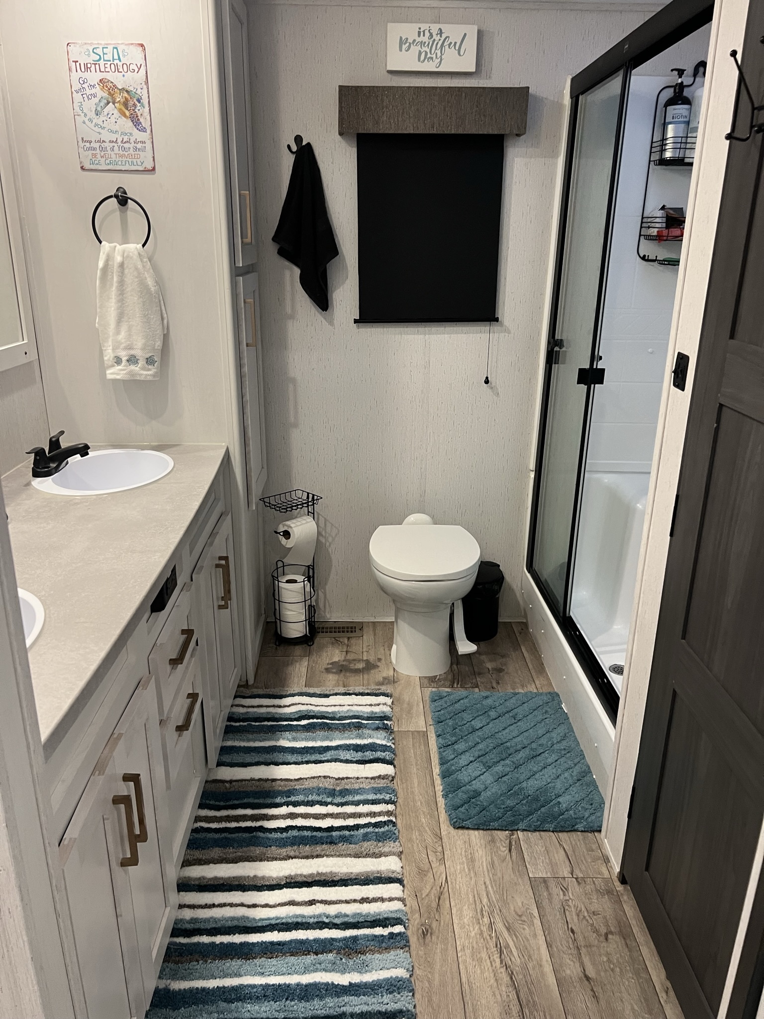 Full RV bathroom with shower, vanity, and toilet