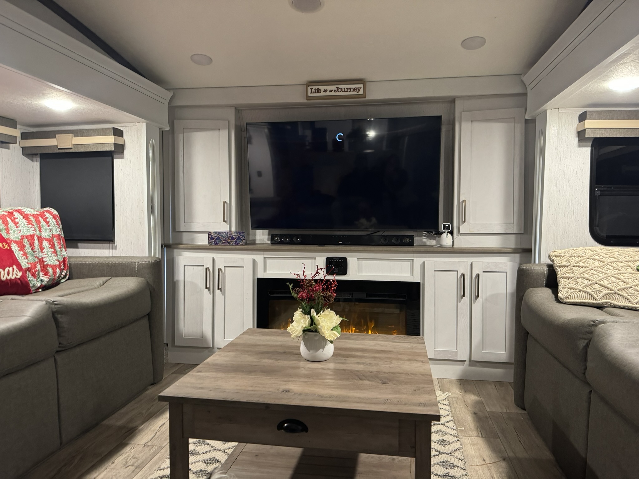 RV lounge seating, entertainment center, and fireplace